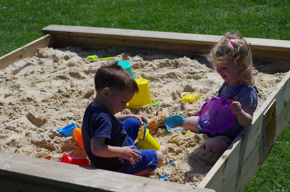 Image of Sandpit with kids playin in it